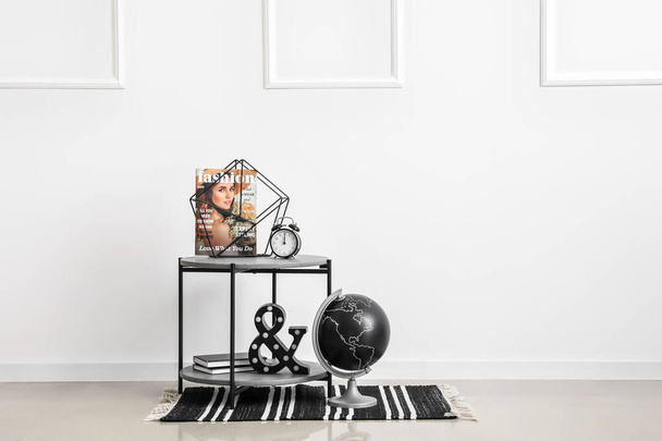 Moderní noční stolek s výzdobou u bílé stěny v pokoji - Fotografie, Obrázek