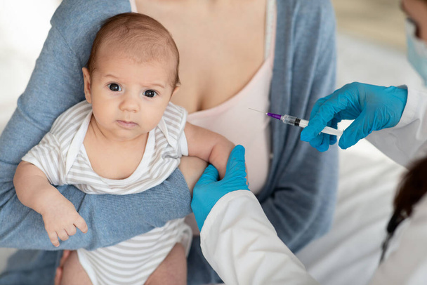 予防接種だ。気づかない小児科医がクリニックで小さな赤ちゃんにワクチンを投与 - 写真・画像