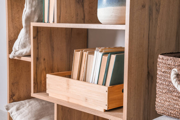 Wooden shelf with books and decor, closeup - Фото, изображение