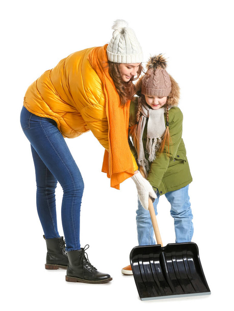 Woman and her little daughter with shovel for removing snow on white background - Fotografie, Obrázek