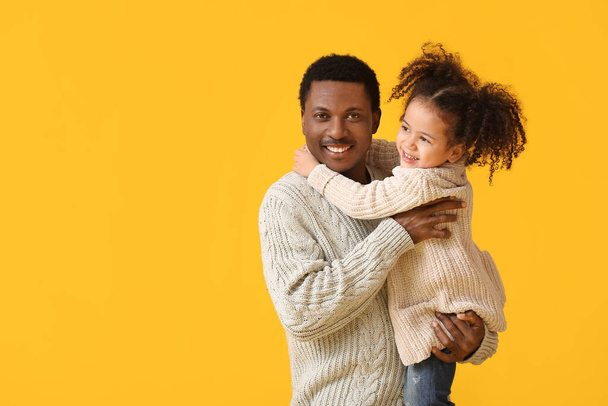 Retrato de feliz padre afroamericano y su pequeña hija sobre fondo de color - Foto, Imagen