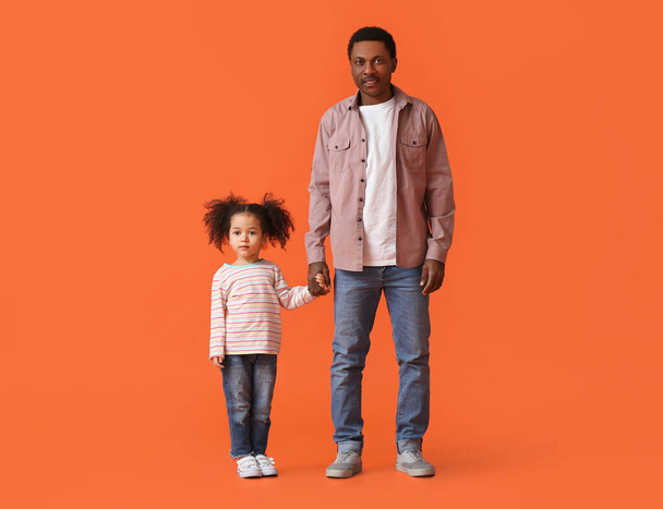 Portrait of happy African-American father and his little daughter on color background - Photo, image