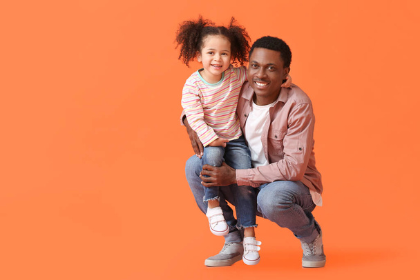 Portrait of happy African-American father and his little daughter on color background - Foto, Bild