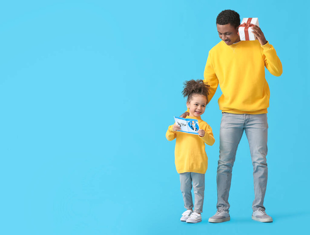 Nettes afroamerikanisches Mädchen begrüßt ihren Vater am Vatertag vor farbigem Hintergrund - Foto, Bild