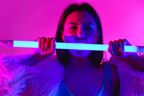 Toned portré gyönyörű fiatal nő neon lámpa színes háttér - Fotó, kép