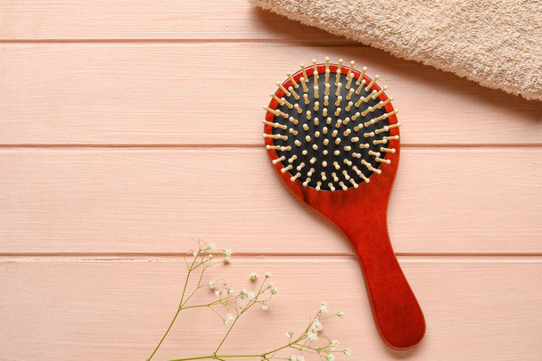 Cepillo para el cabello con toalla sobre fondo de madera - Foto, Imagen