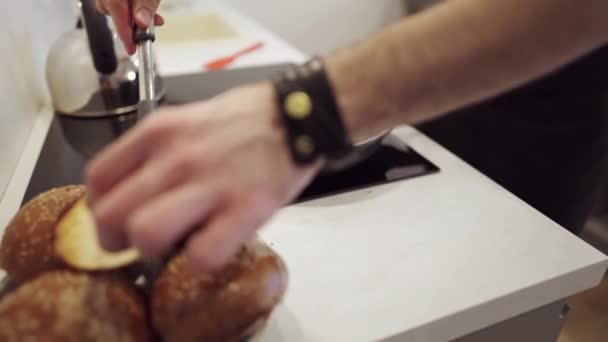 Hombre cocina hamburguesas de carne en casa en la cocina - Imágenes, Vídeo