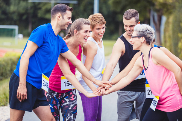 Skupina maratonských běžců stohuje ruce - Fotografie, Obrázek
