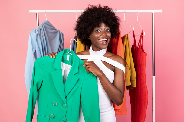 Excited Black Woman Shopping Holding Bright Jacket Posing, Pink Background - Photo, Image