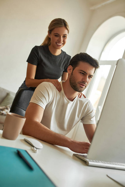 Young woman helps her mate to chill while he is working - Photo, image