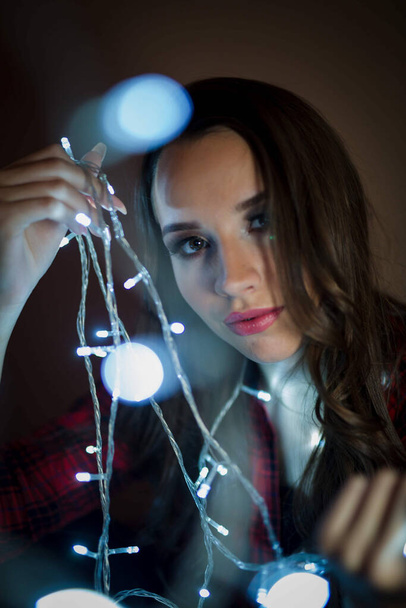 Um retrato vertical close-up de uma jovem menina bósnia atraente com luzes bokeh Natal - Foto, Imagem