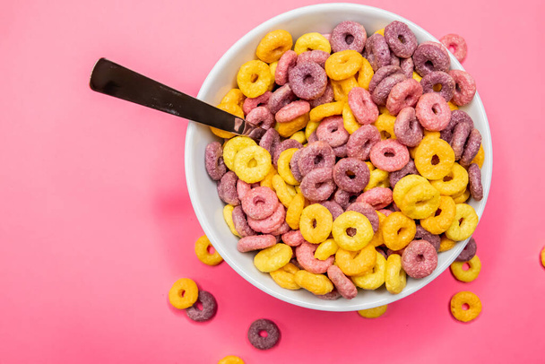 A top view of breakfast cereal rings in bowl isolated on pink background - Foto, Bild