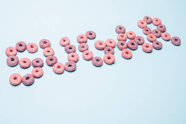 A closeup shot of crunchy cereal lined up as the word sugar - Fotoğraf, Görsel