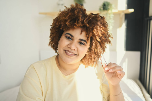 Közelkép napfényes portré boldog mosolygós görbe plusz méret Afrikai fekete nő afro haj smink pózol bézs pólóban. A test tökéletlensége, a test elfogadása, a test pozitív és sokszínű koncepciója - Fotó, kép
