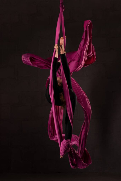 Flexible teen doing aerial silks trick on fabric - Valokuva, kuva
