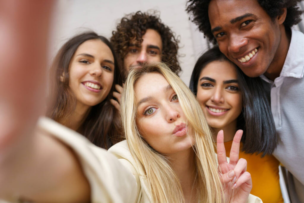 Multi-etnische groep van vrienden het nemen van een selfie samen terwijl het hebben van plezier buiten. - Foto, afbeelding