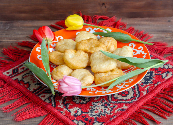 Nationale Kazachse gebakjes baursaki in een bord op een houten achtergrond - Foto, afbeelding