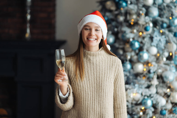 Beautiful young woman with glass of champagne at home. - Photo, Image