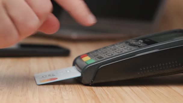 Close-up man hand vegen credit card en voert een pin code met behulp van POS terminal voor de betaling.  - Video