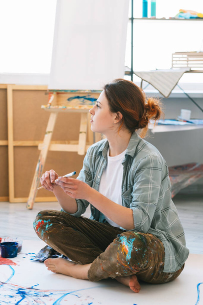 painting art pensive female artist in workshop - Zdjęcie, obraz