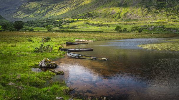 4 zatopione i zanurzone łodzie wiosłowe w Lough Gummeenduff w pięknej Czarnej Dolinie, góry MacGillycuddys Reeks, Pierścień Kerry, Irlandia - Zdjęcie, obraz