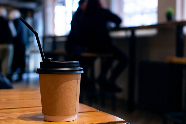 Бумажная чашка кофе на столе в кафе крупным планом - Фото, изображение