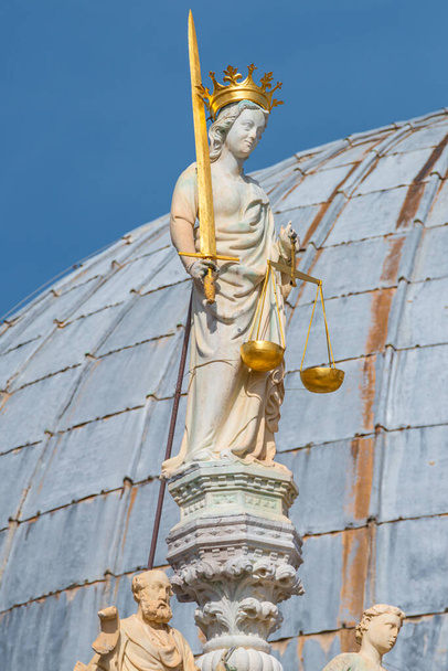 Az igazságosság istennője karddal és léptékkel díszítő elemként a velencei San Marco bazilika tetőin és kupoláin, napsütéses nappal és a kék ég mélyén - Fotó, kép