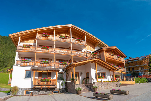 Panoramatický výhled na magické vrcholy Dolomit, lesy a hotely za slunečného dne a modré oblohy, Colfosco, Corvara, v Puez-Geisler, Puez-Odle Nature Park, Jižní Tyrolsko, Itálie - Fotografie, Obrázek
