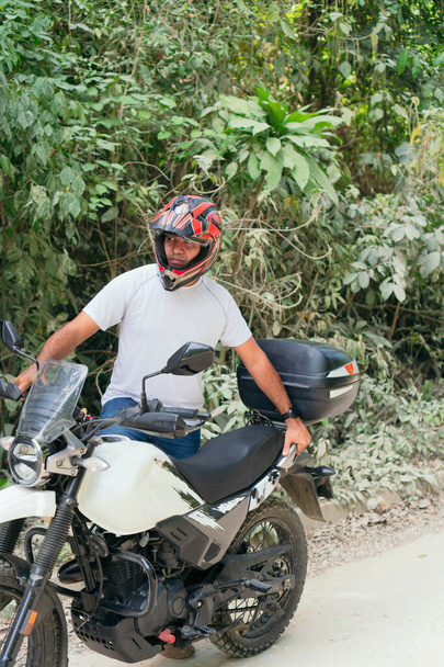 Kırsal bir yolda motosikletinin yanındaki İspanyol adam. - Fotoğraf, Görsel