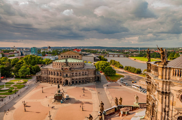 Вид на исторический центр Дрездена с высоты птичьего полета через Эльбу, а также на здание Государственной оперы в Дрездене, Германия, летом, во время заката с тяжелыми облаками - Фото, изображение