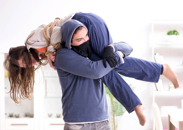 Homme armé agressant une jeune femme à la maison - Photo, image