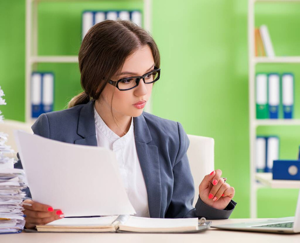 Young female employee very busy with ongoing paperwork - 写真・画像