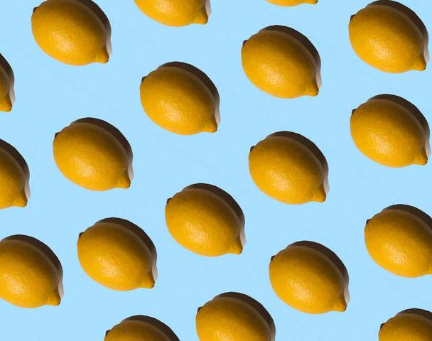 Multiplied lemons with shadows on pastel blue background. Tropical fruits.  Summer concept. - Foto, afbeelding