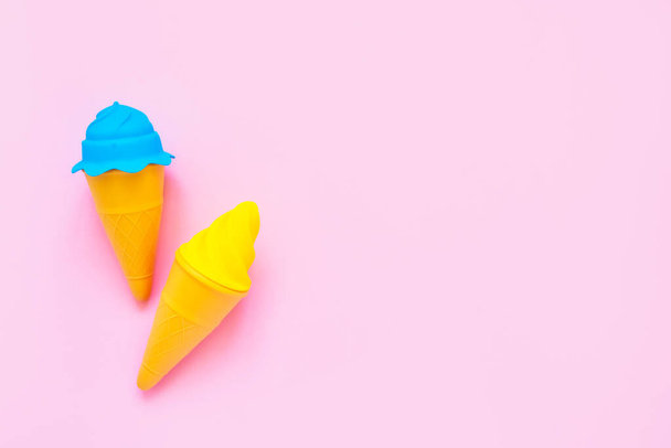 Синьо-жовтий іграшковий морозиво на рожевому фоні. Мінімалізм, літня концепція. Вид зверху, простір для копіювання тексту
. - Фото, зображення