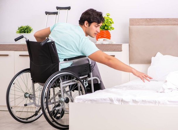 Fiatal jóképű fogyatékkal élő férfi lábadozik otthon - Fotó, kép