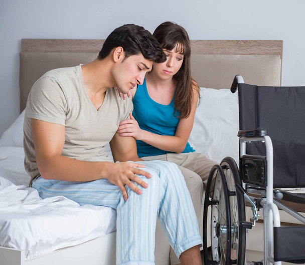 Homem desesperado em cadeira de rodas com sua esposa triste - Foto, Imagem