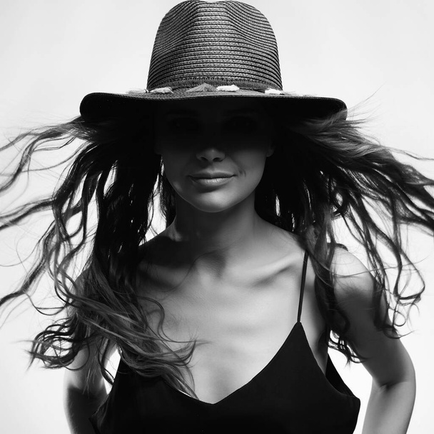 piękna szczęśliwa kobieta w kapeluszu, z kręconymi długimi włosami. piękno czarny i biały portret zdrowe włosy dziewczyna - Zdjęcie, obraz