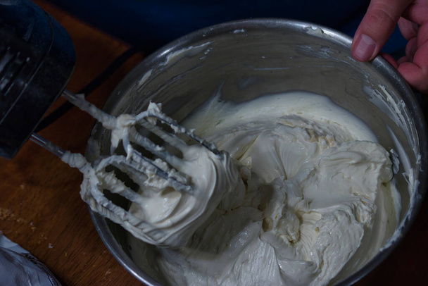 an electric mixer with whipped cream coating the beaters - Photo, Image
