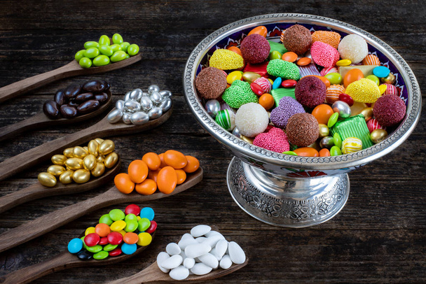 Bowl of candies and chocolate on the wooden table. Many types of candy.  - Photo, Image