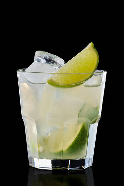 Cold lime refreshing drink in rocks glass isolated on black - Foto, Imagen