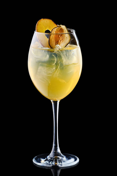 Pear and apple sangria in a wine glass isolated on black background - 写真・画像