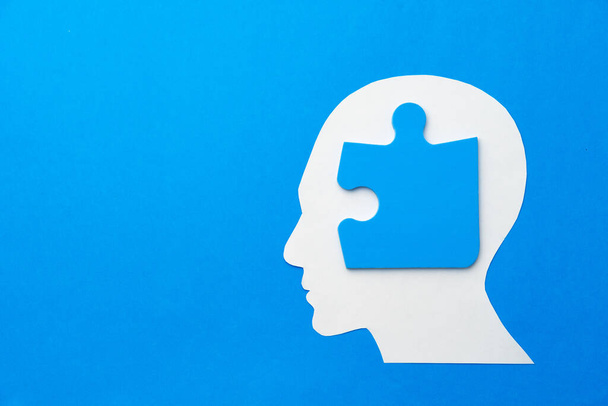 Papercut head with jigsaw puzzle pieces on blue background - Zdjęcie, obraz