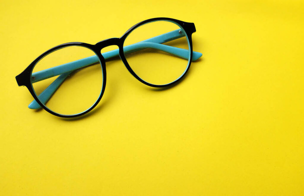 kopieer ruimte rond zwart Eye Glasses isoleren op gele achtergrond - Foto, afbeelding