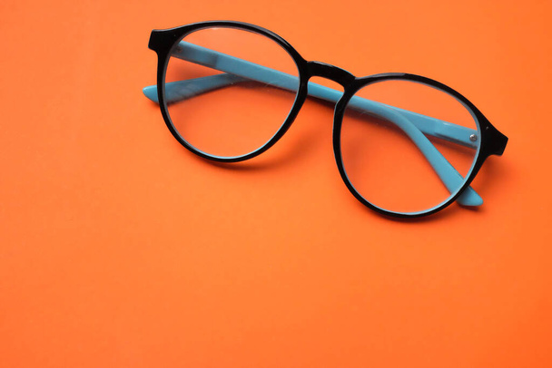 Kopierraum runde schwarze Augenbrille isoliert auf orangefarbenem Hintergrund - Foto, Bild