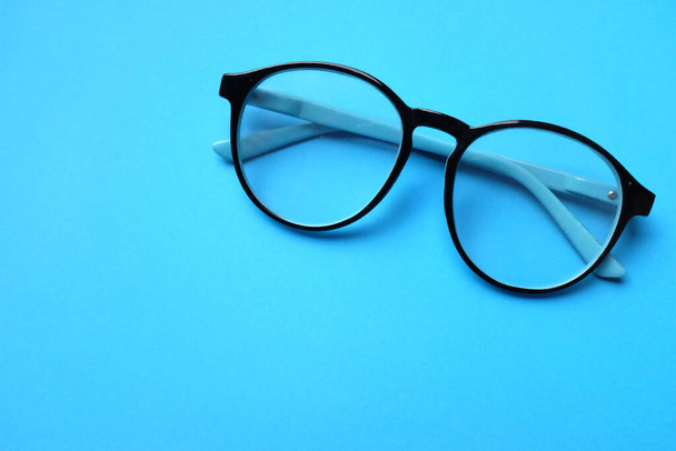 copiar espacio redondo negro Ojo gafas aislar sobre fondo azul - Foto, Imagen