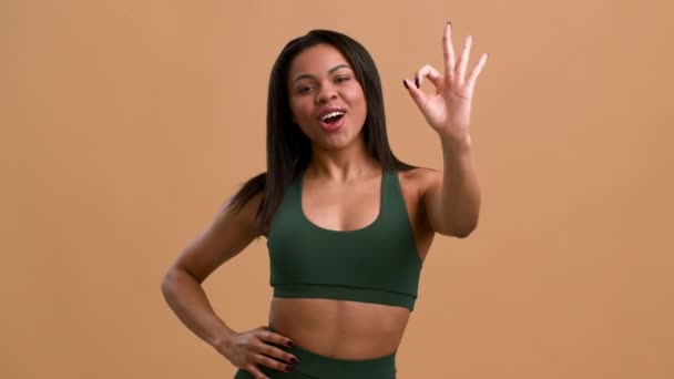 Fit Black Lady Gesturing Oké mosolygós kamera, bézs háttér - Felvétel, videó