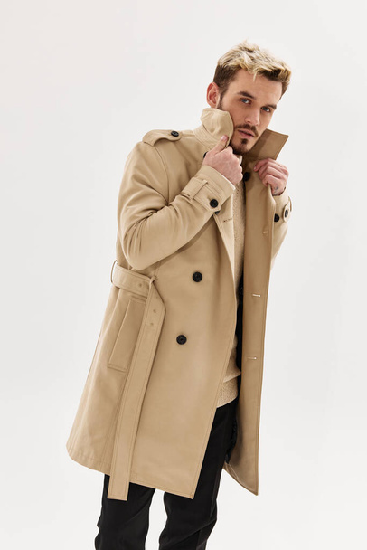 man in beige coat holding collar fashion lifestyle isolated background - Photo, Image