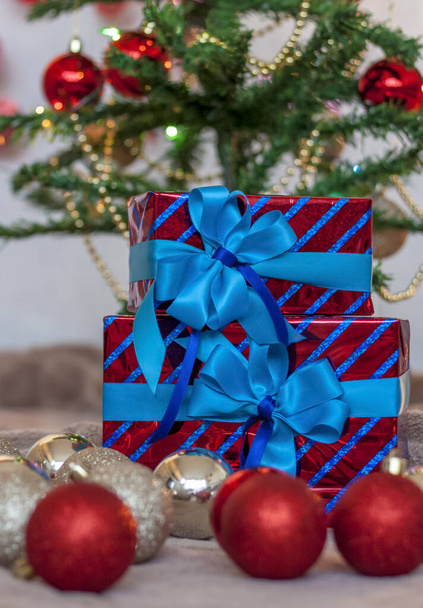 Holiday gifts with blue bows under the tree. Christmas and New year. The concept of an advertising banner.  - Foto, Bild