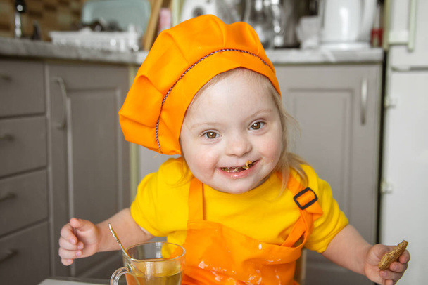 child with Down syndrome chef, a portrait of a disabled girl. - Photo, Image