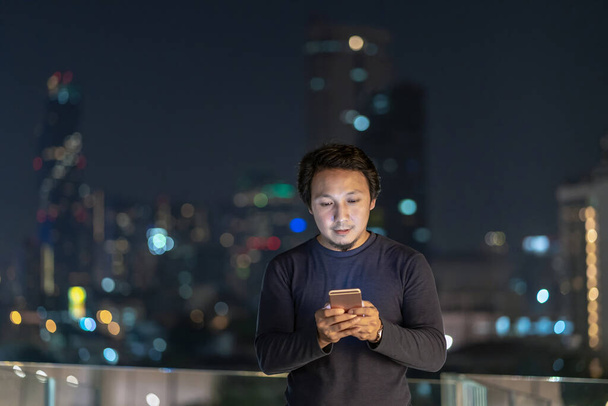 バンコク川沿いの金融街で笑顔のアクションを持つスマートフォンを使用してアジアの創造的なフリーランス,タイ,キャリアの概念を持つ技術 - 写真・画像